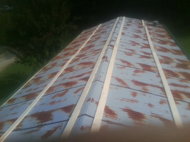 Rusted metal roof panels with new wood purlins before replacement — Storm Damage Roof Repair in Waring by Roofing Brothers