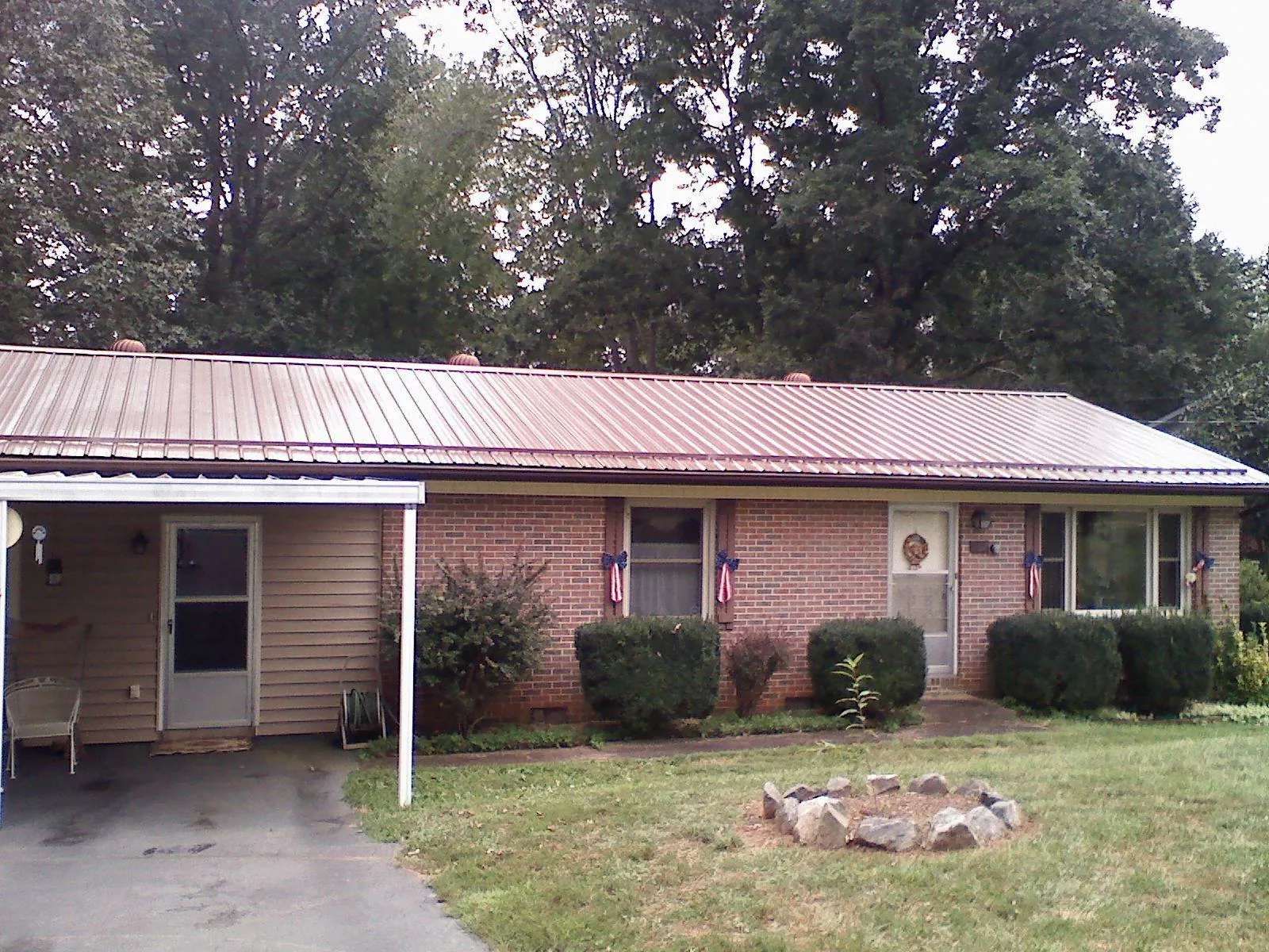 Bronze metal roof and carport on a brick ranch home — Roof Repair work by our crew in Waring
